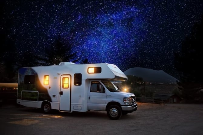 Mobile Camper parked in the middle of the night under a starry sky use for travel nurse housing